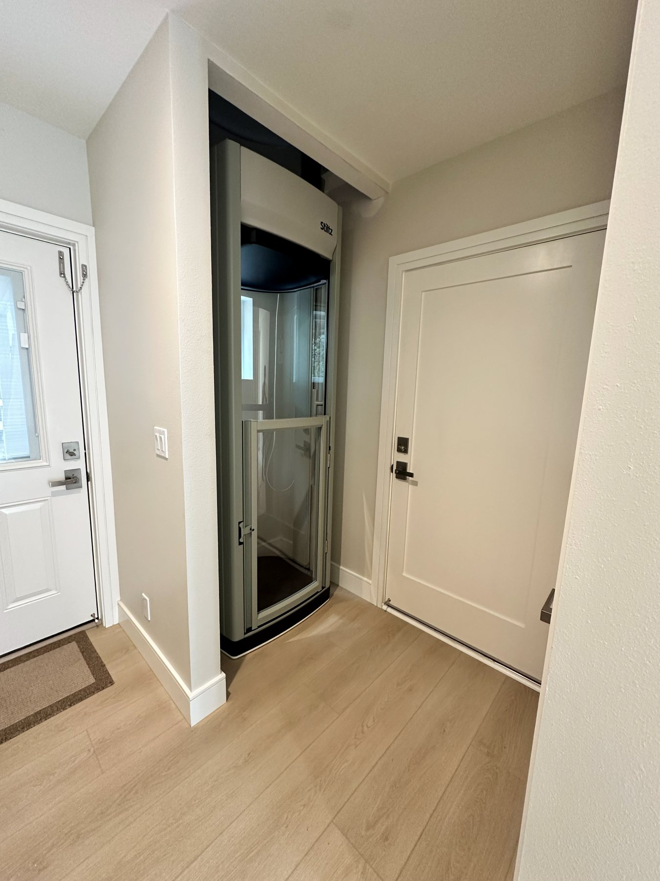 Primary bathroom with a double vanity, backlit mirrors, and a glass-enclosed shower.
