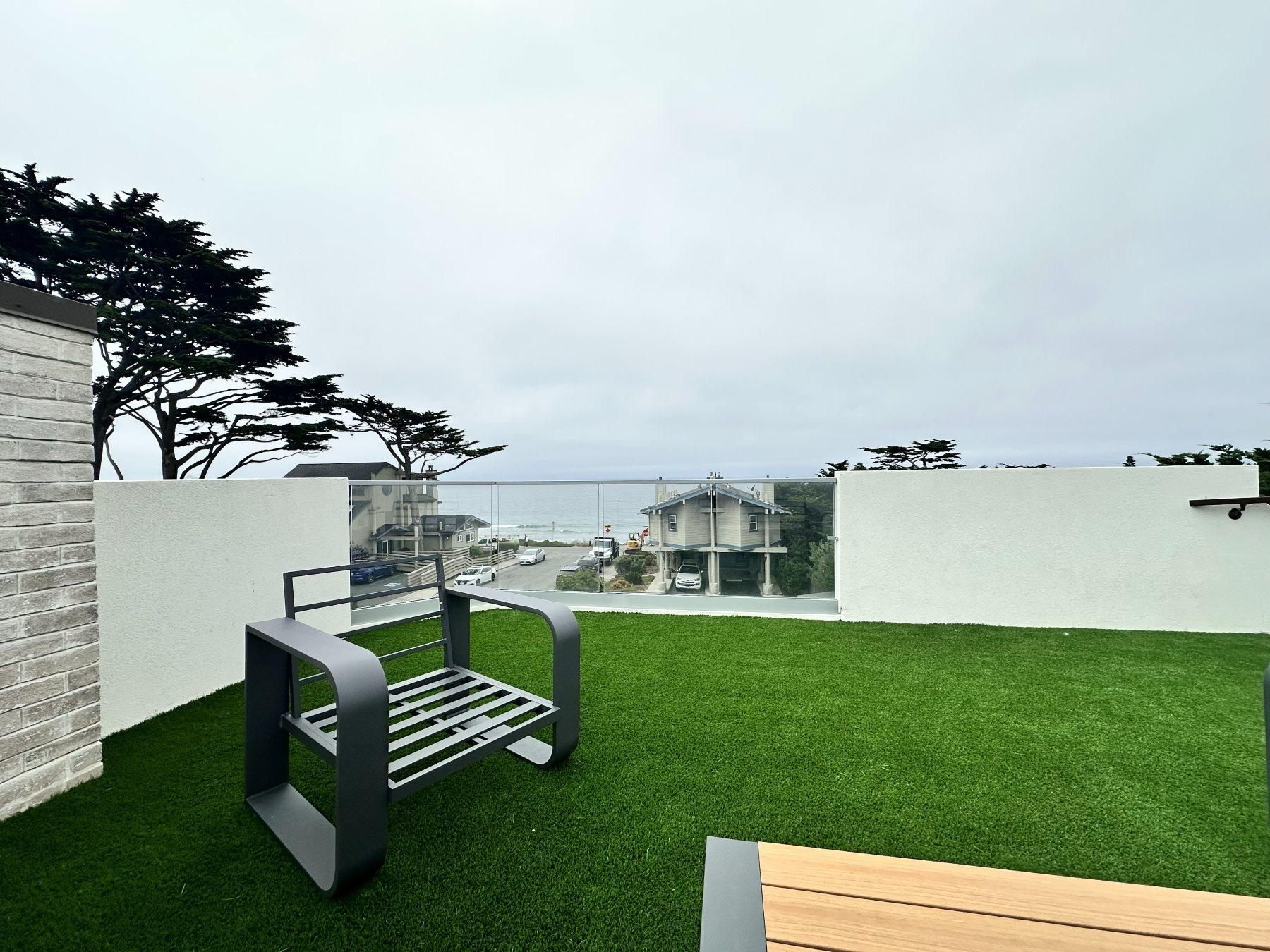 A lounge chair on the rooftop deck, overlooking the neighborhood rooftops and the coastline.