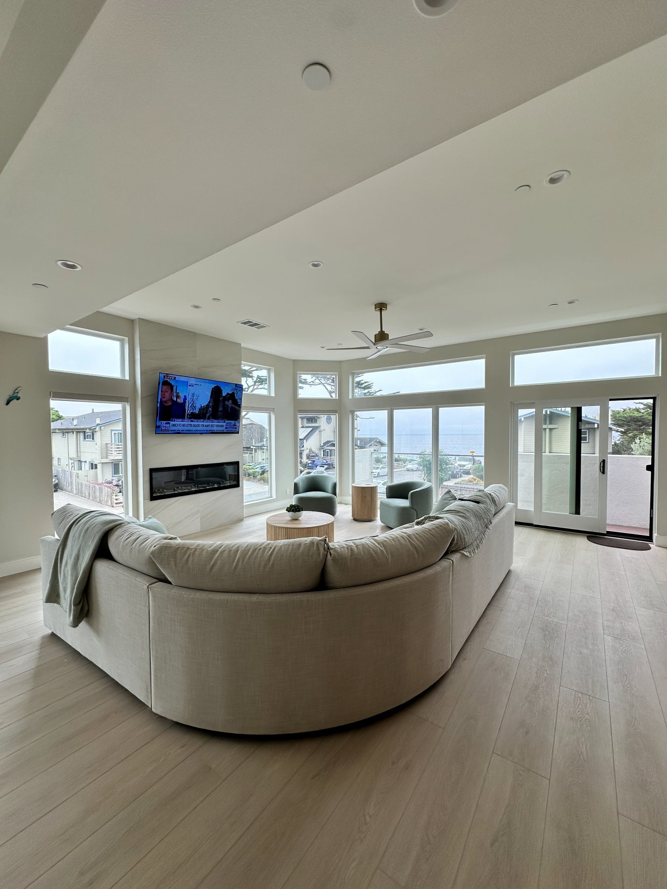 The living room's curved sectional and linear fireplace, seen from the dining area.