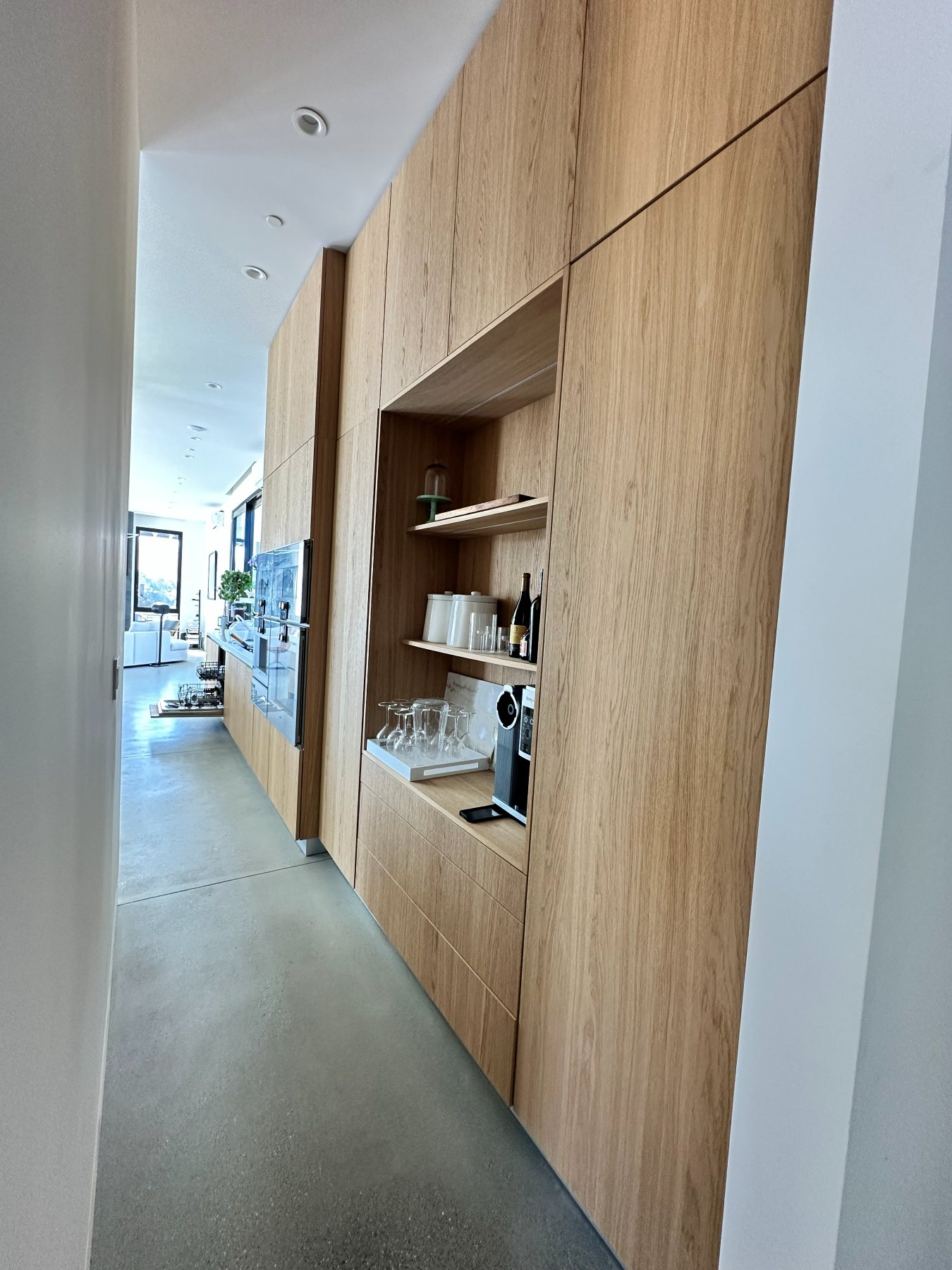 A wine and bar nook with open wood shelving and glass storage.