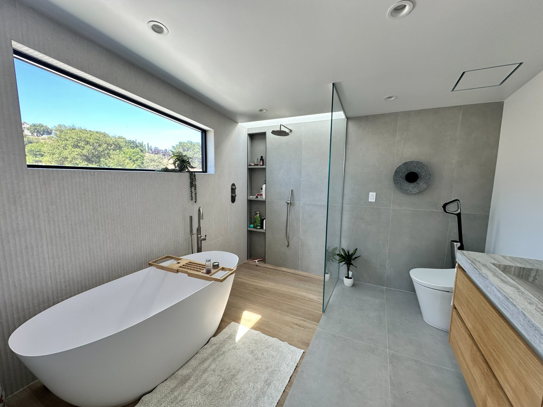 Primary bathroom with a freestanding soaking tub beneath an angled window.