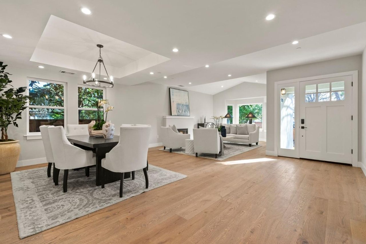 Living and dining area open to the entry, with a gas fireplace and a vaulted ceiling.